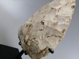 a close up of a stone object on a stand against a gray sky