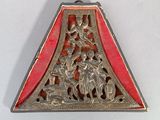 a silver and red triangle shaped object on a white surface