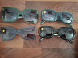 Plusieurs paires de lunettes de soleil sont alignées sur une surface en bois