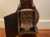 a small clock that is sitting on a wooden floor