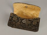 an image of a black and gold purse sitting on top of a table