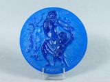a close up of a blue plate with a statue on it