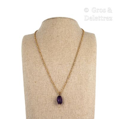 Collier avec une pierre d'améthyste et une chaîne en or sur un mannequin