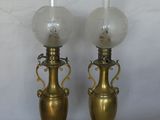 paire de vases anciens en laiton avec des globes en verre, posés sur des socles
