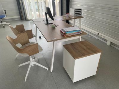 un bureau avec deux chaises et un écran d'ordinateur posé dessus