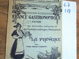 un vieux guide gastronomique français posé sur une table, à côté d'un bloc-notes