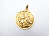 a close up of a gold medal with a woman holding a child