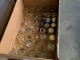 a box of empty wine glasses and a container of empty wine glasses on the floor
