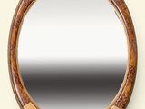 a round mirror with a wooden frame on the wall