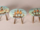 trois petits tabourets en bois sur lesquels est peinte une image de bateau