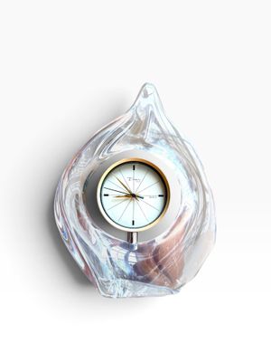 a clock that is sitting in the shape of a shell