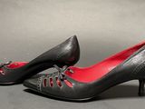 pair of women ' s black leather shoes with red laces