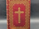 a red book with a gold cross on the cover