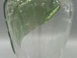 a glass vase with a green leaf on it