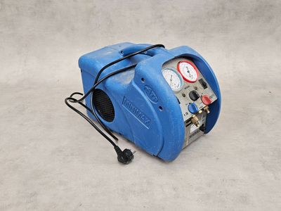 a blue air compressor sitting on top of a cement floor