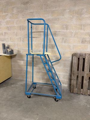 un chariot bleu sur lequel est posée une échelle, dans une pièce