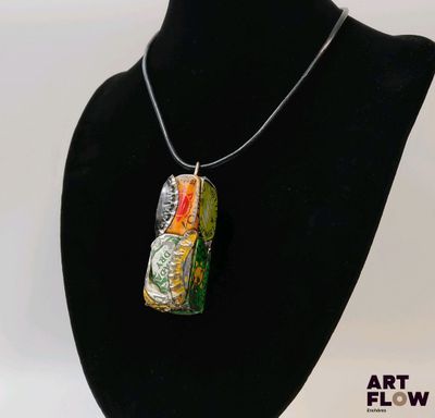 a necklace that has a bottle on it on a mannequin