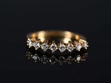 a close up of a gold ring with diamonds on a black surface