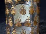 a glass jar that has a gold design on it