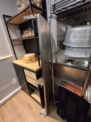 une cuisine équipée d'une cuisinière, d'étagères et d'un évier