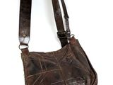 brown leather purse with fringes hanging on a white wall
