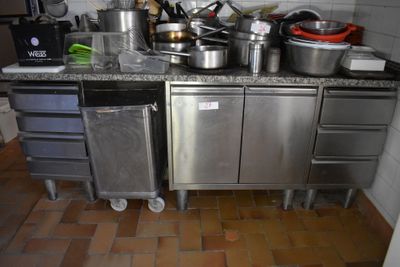 Il y a beaucoup de casseroles et de poêles sur le plan de travail de cette cuisine