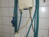 des toilettes équipées d'un tuyau dans une salle de bains