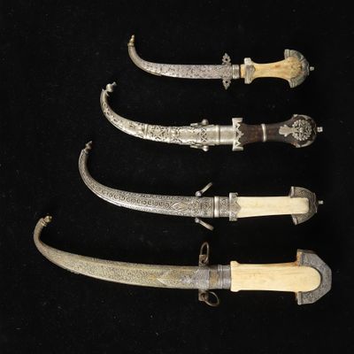 four different types of knifes are displayed on a black surface