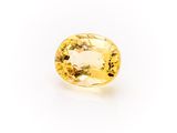 a yellow sapphire stone on a white background