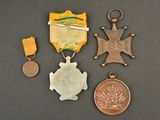 three medals and a medal on a black surface