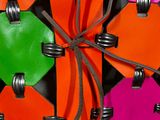 brightly colored leather luggage tags tied to a black and orange suitcase