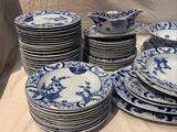 a lot of blue and white china plates on a table