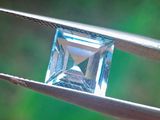 un diamant bleu tenu par une pince