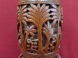 un vase en bois orné de sculptures sur un fond rouge