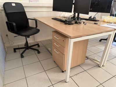 a desk with two computer monitors on it and a black chair