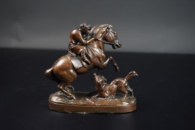 statue en bronze représentant un homme à cheval, avec un chien qui court derrière lui