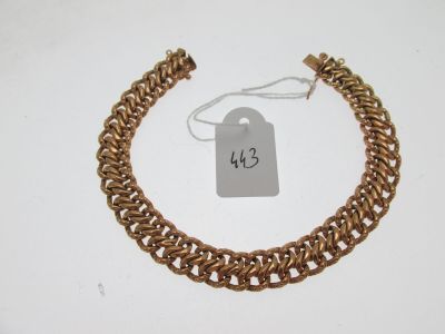 gros plan d'un bracelet en chaîne en or avec une étiquette de prix