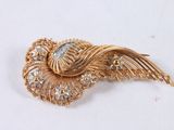 an image of a gold and diamond broochle on a white surface