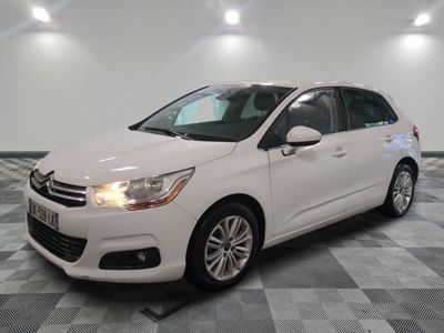 Une Citroën blanche est garée sur un sol carrelé à damier