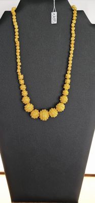 un collier composé de perles jaunes sur un mannequin noir