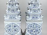 pair of chinese blue and white vases on stands on a gray background