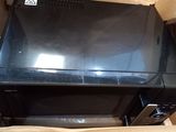 a black microwave sitting inside of a box on the floor