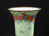 une image représentant un vase vert orné d'oranges et de fleurs bleues