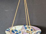 a close up of a plate hanging from a rope on a wall
