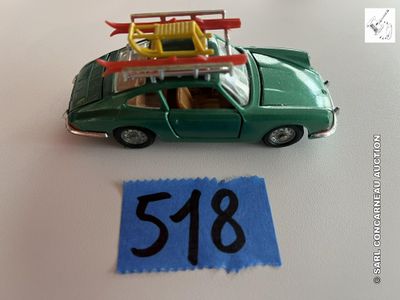 une petite voiture verte avec une planche de surf posée dessus