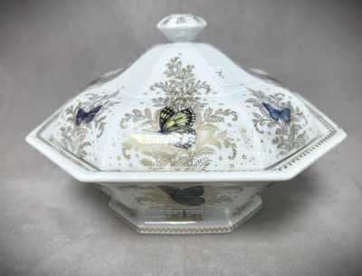 un plat de service blanc et doré orné de papillons