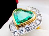 a ring with a heart shaped green stone in it