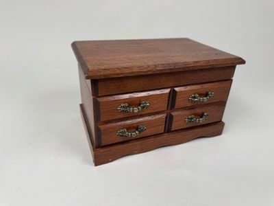 une petite boîte en bois surmontée de trois tiroirs