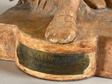 a statue of a man riding a horse on a wooden base