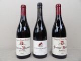 three bottles of red wine sitting on a table next to each other